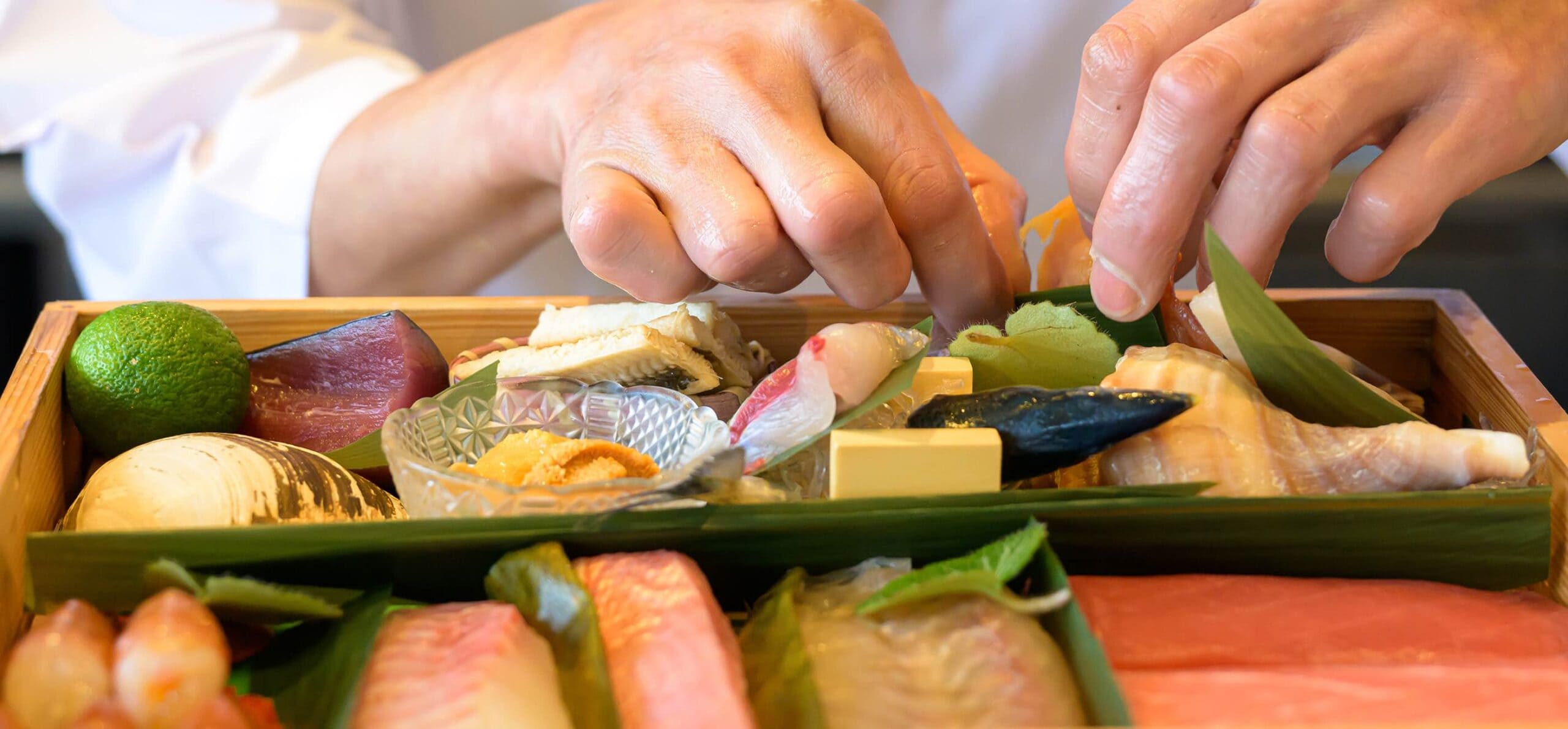 ネタ箱に丁寧に料理を盛り付ける様子