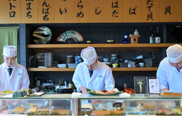カウンター内で仕込みと調理を行う寿司職人たち
